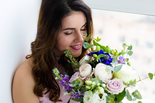 Beautiful woman with a lovely bouquet - Фото, зображення