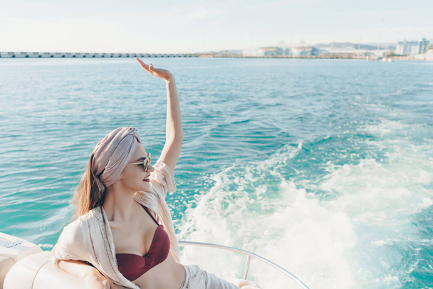 a wealthy confident woman sails on her white yacht on the sea, went on a trip - Fotoğraf, Görsel