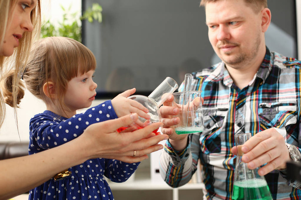 Mann und kleines Mädchen spielen mit bunten Flüssigkeiten - Foto, Bild