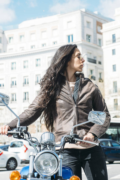 mujer con una motocicleta en la ciudad - Foto, Imagen