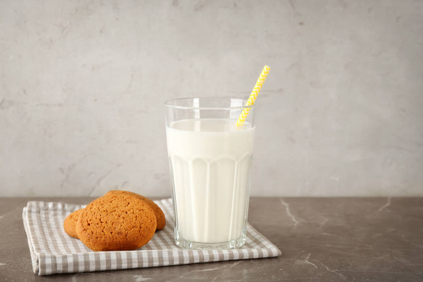 Glass of milk and oatmeal cookies on table. Fresh dairy product - Фото, изображение