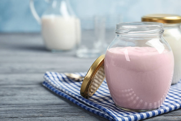 Jar with tasty yogurt on table - Foto, imagen