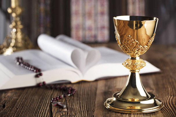 Святое причастие. Крест, Священная Библия, четки и золотая чаша
. - Фото, изображение