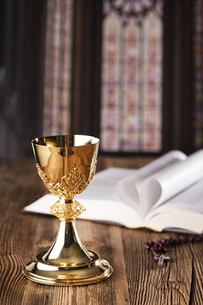 Holy communion concept. Holy Bible, rosary and golden chalice. - Photo, Image