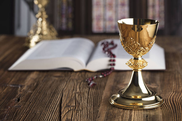 Szentáldozás koncepció. A kereszt, a Szent Biblia, a rózsafüzér és a golden chalice. - Fotó, kép