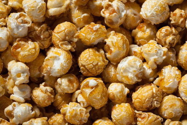 Gouden karamel popcorn close-up. Achtergrond van popcorn. Snacks en eten voor een film - Foto, afbeelding