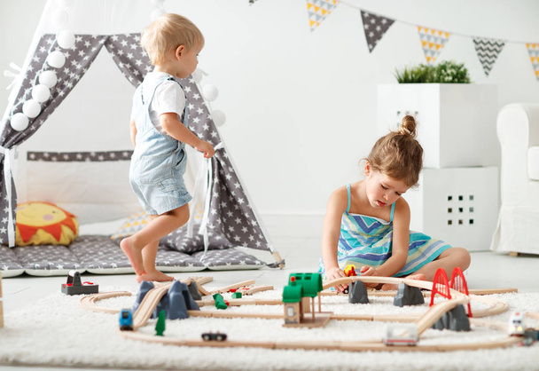 χαρούμενα παιδιά που παίζουν σε παιχνίδια στο σπίτι σε playroom - Φωτογραφία, εικόνα