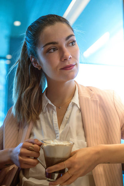 Young beautiful woman portrait drinking coffee in a restaurant - Fotoğraf, Görsel