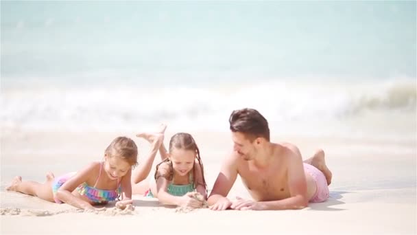 Baba ve çocuklar beyaz kumsalda yalan - Video, Çekim