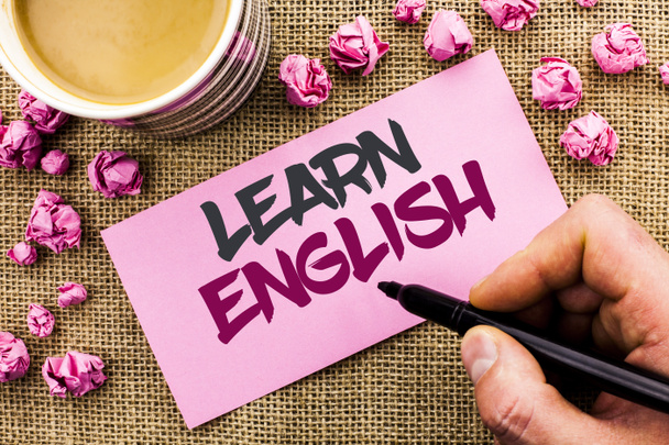 Conceptual hand writing showing Learn English. Business photo text Study another Language Learn Something Foreign Communication written by Man Holding Marker on Paper on the jute background Cup - Photo, Image