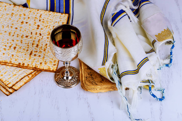 koscherer Wein mit einem weißen Teller Matza oder Matza und einer Pessach-Haggada auf einem Vintage-Holz-Hintergrund - Foto, Bild