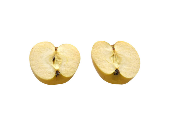 Pomme jaune mûre coupée en deux moitiés. Sur fond blanc
 - Photo, image