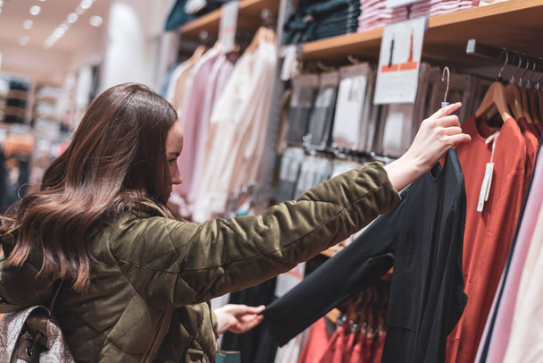 Una giovane ragazza cammina per il negozio e prezzi per le cose. concetto di shopping
 - Foto, immagini