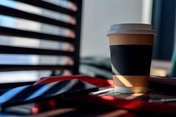 Бумага и картон Кубок с кофе, капучино, латте, чай на деревянном столе в кафе при ярком солнечном свете из окна весной
 - Фото, изображение
