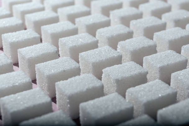 Cubes of refined white sugar the correct geometric shape on a pink background. Minimalistic abstract screensaver - Φωτογραφία, εικόνα