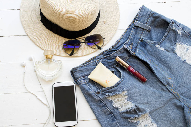 korte broek denim jeans met zonnebrand spf 50 voor huid gezicht en accessoires vrouw ontspannen zomer op witte achtergrond - Foto, afbeelding