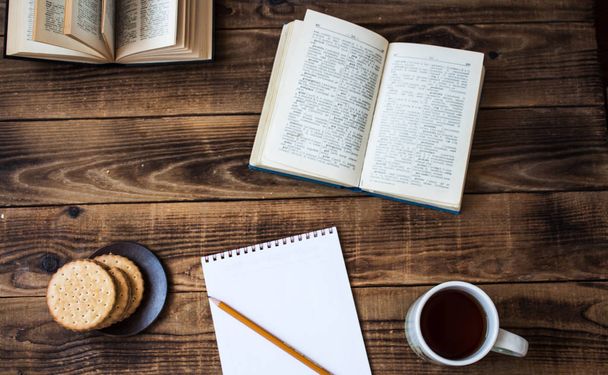 cookie-k és tea nyitott könyv ceruza notebook fából készült háttér - Fotó, kép