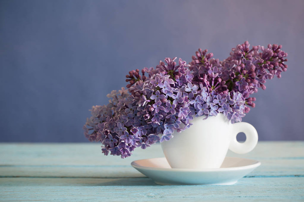 lilac in cup on old wooden table - Фото, зображення