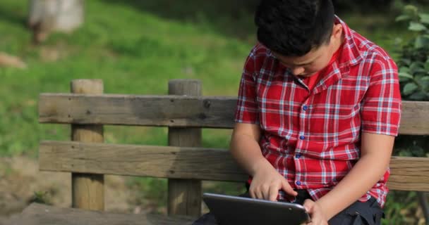 Portret kaukaski nastolatek z cyfrowym tablecie komputera w przyrodzie - Materiał filmowy, wideo
