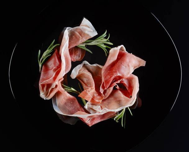 Prosciutto with rosemary. - Фото, изображение