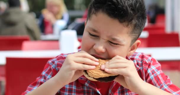 Kind isst Hamburger im Restaurant - Filmmaterial, Video