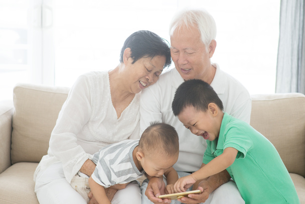 Großeltern und Enkel mit Smartphones  - Foto, Bild