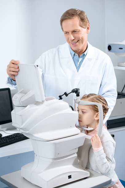 Augenarzt untersucht Sehvermögen präpubertärer Kinder in Klinik - Foto, Bild
