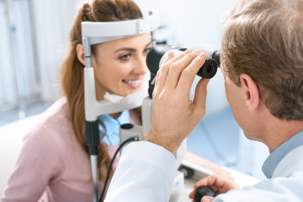 oculista examinar a visão do paciente com lâmpada de fenda na clínica
 - Foto, Imagem