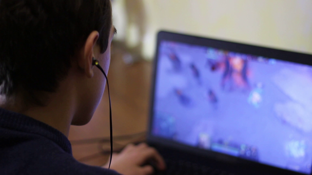 若い男は、ゲームの前に彼のヘッドフォンを置きます。ティーンエイ ジャー オンライン ギャンブル中毒。多人数オンラインバトル アリーナ - 映像、動画