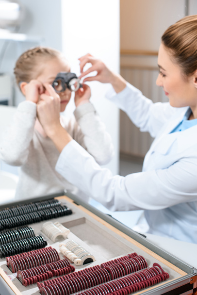 Augenarzt untersucht Kinderaugen mit Proberahmen und Linsen - Foto, Bild