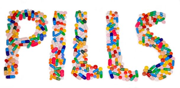 Pills letters made from tablets and capsules on white table, medical treatment - Fotó, kép