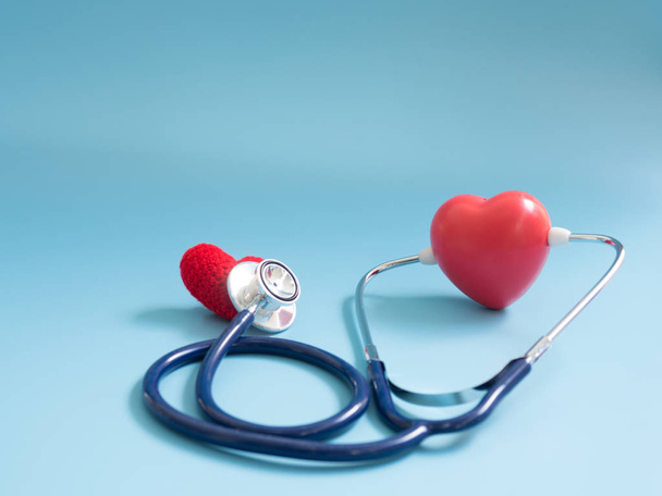 red heart using deep blue stethoscope on the blue background for hear their other heart. Concept of love and caring patient by the heart. Copy space for the text and contents - Photo, Image