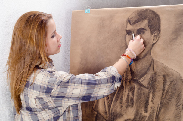 Jovem artista feminina desenho homem retrato em seu estúdio de arte
. - Foto, Imagem