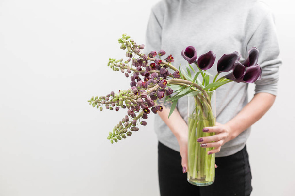Όμορφο μοβ-καφέ Fritillaria και Calla ανθοδέσμη. Άνοιξη λουλούδια στο χέρι γυναίκα. το έργο του το ανθοπωλείο σε ένα ανθοπωλείο. Οριζόντια φωτογραφία - Φωτογραφία, εικόνα