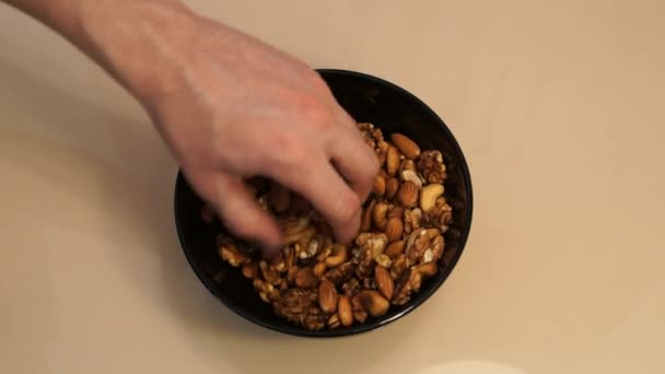 Nuts mix. Cashew. Walnut. Almond. Man hands take nuts. Assorted nuts - Záběry, video