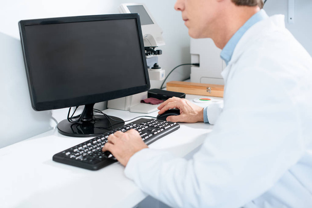 cropped view of male optician working with computer in clinic - Foto, afbeelding