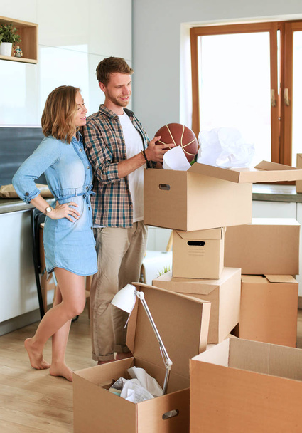 Couple unpacking cardboard boxes in their new home. Young couple. - Photo, Image