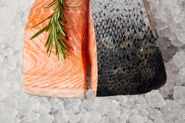 top view of sliced red fish fillet with rosemary on crushed ice - Foto, Bild