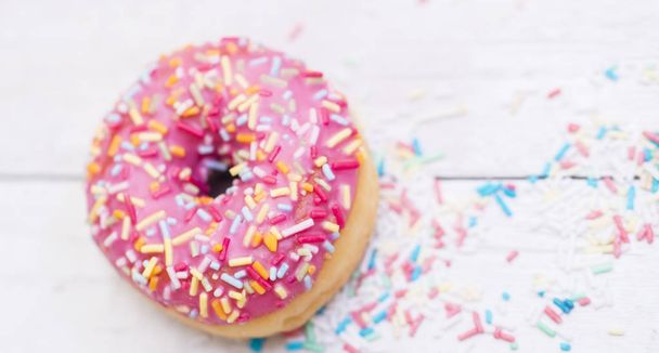 Pink donuts with sparkles  on wooden table  - Foto, Imagem