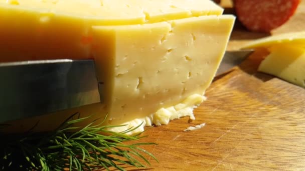 cheese cut with a knife on a wooden, slow-motion shot - Footage, Video