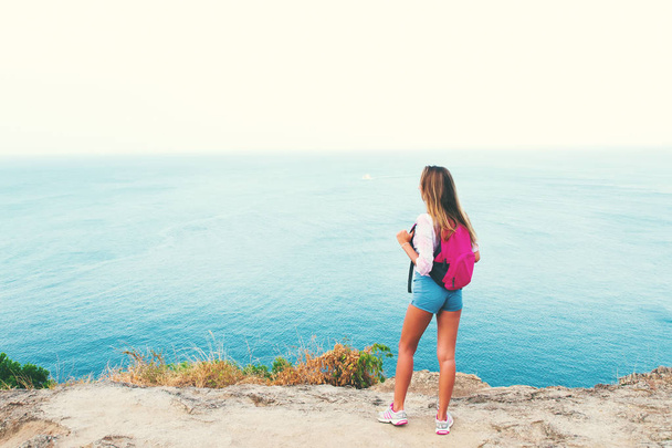 back view blonde girl backpacker standing shore island - Foto, Bild