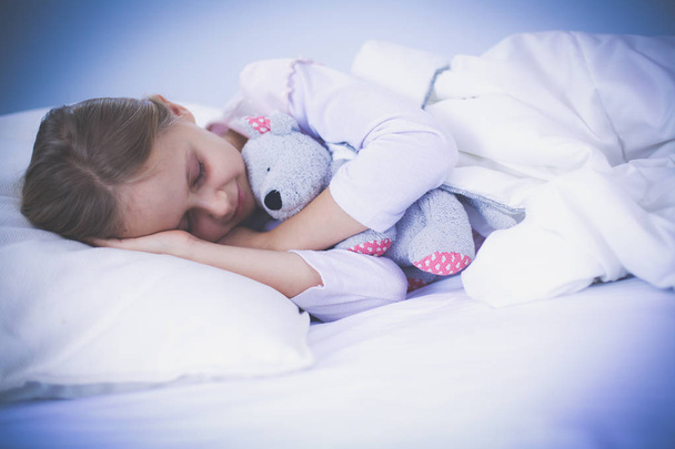 Child little girl sleeps in the bed with a toy teddy bear. - Fotoğraf, Görsel