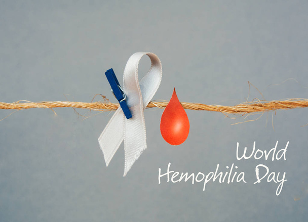 Awareness poster with red paper cut blood drop and red ribbon symbol . Blood donor day or World Hemophilia Day   - Fotoğraf, Görsel