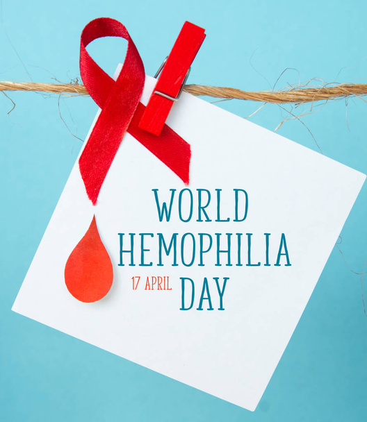 Awareness poster with red paper cut blood drop and red ribbon symbol . Blood donor day or World Hemophilia Day   - 写真・画像