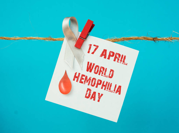 Awareness poster with red paper cut blood drop and red ribbon symbol . Blood donor day or World Hemophilia Day   - Foto, immagini