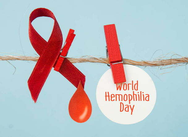 Awareness poster with red paper cut blood drop and red ribbon symbol . Blood donor day or World Hemophilia Day   - Foto, Imagem