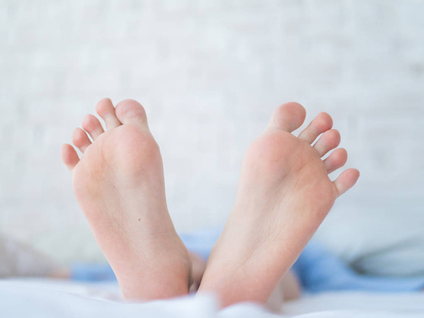 female feet, toes showing under the sheet - Fotoğraf, Görsel