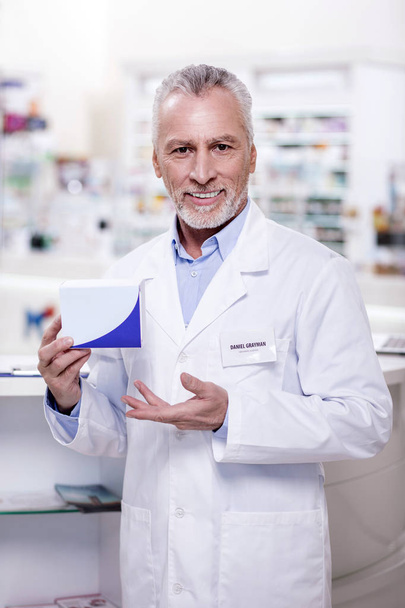 Happy male pharmacist advertising medication - Foto, imagen