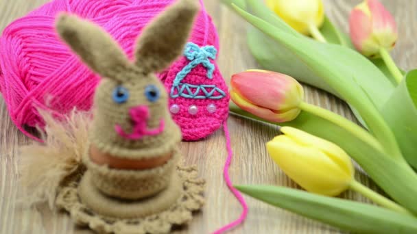 Crochet Easter bunny egg cup made of wool. fresh tulips and wool ball in background - Footage, Video