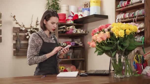 Hermosa chica trabaja en una floristería
 - Metraje, vídeo